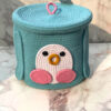 Close up shot of handcrafted premium teal penguin storage basket with pink accent loop