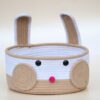 Front view of minimalist woven cotton rope bunny basket featuring standing ears and cute face design