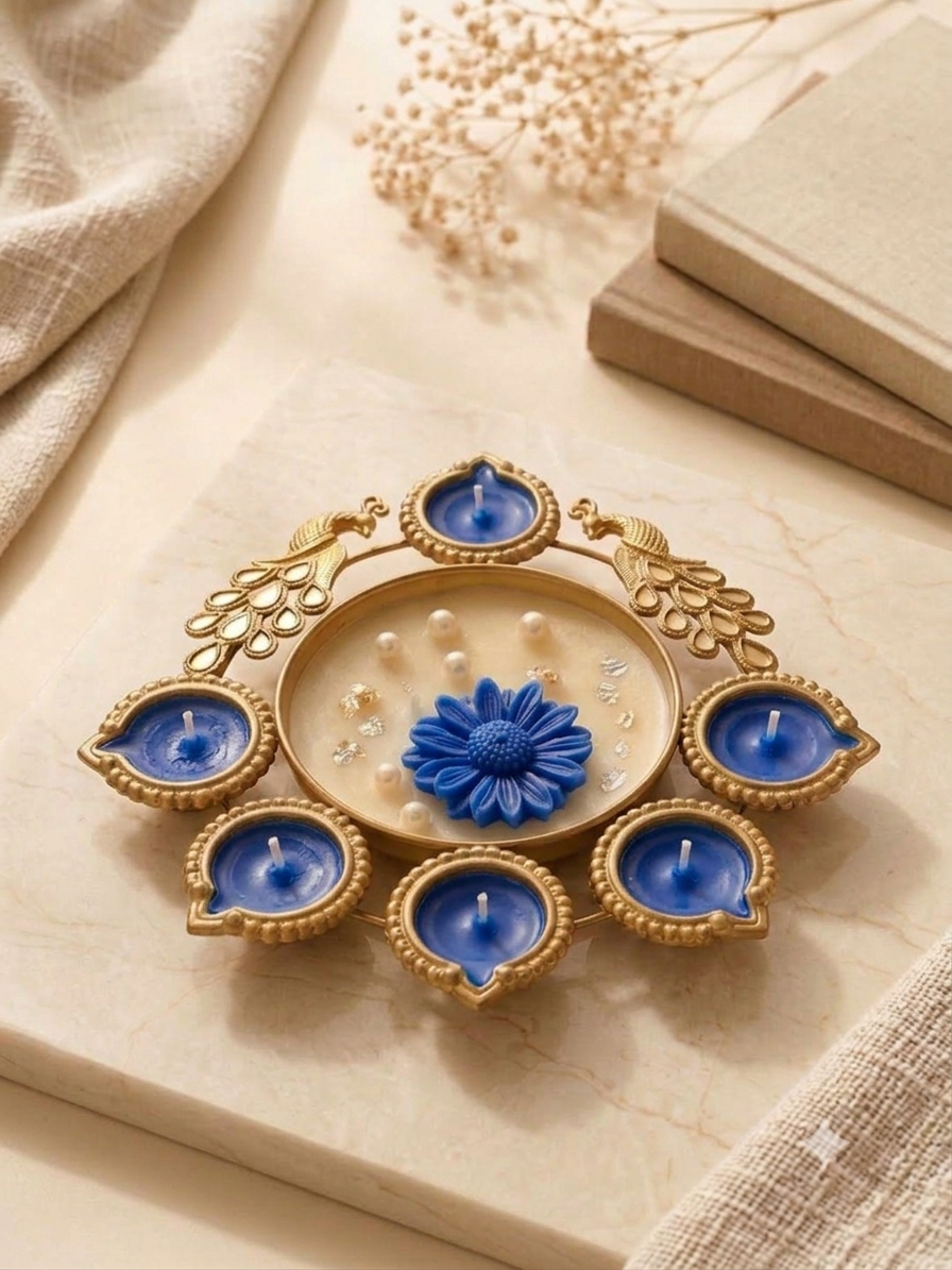 Gold peacock metal diya platter with sky blue wax candles and central pearl flower dish