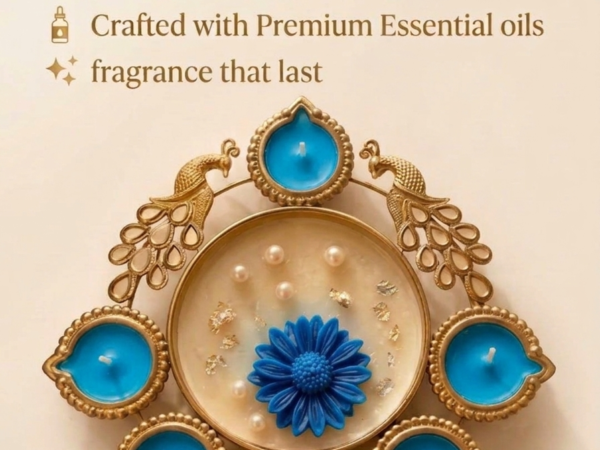 Gold peacock metal diya platter with sky blue wax candles and central pearl flower dish